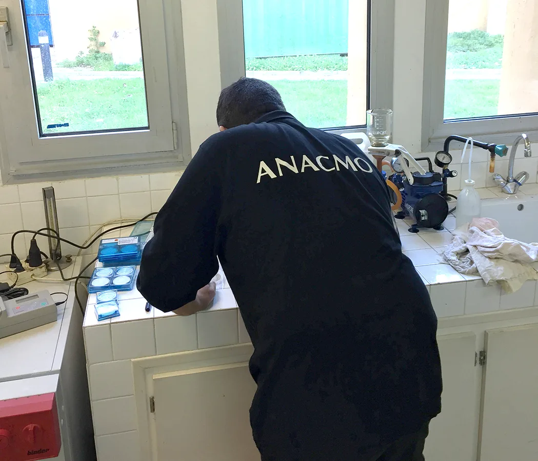 Technicien ANACMO réalisant des analyses de fluides en laboratoire