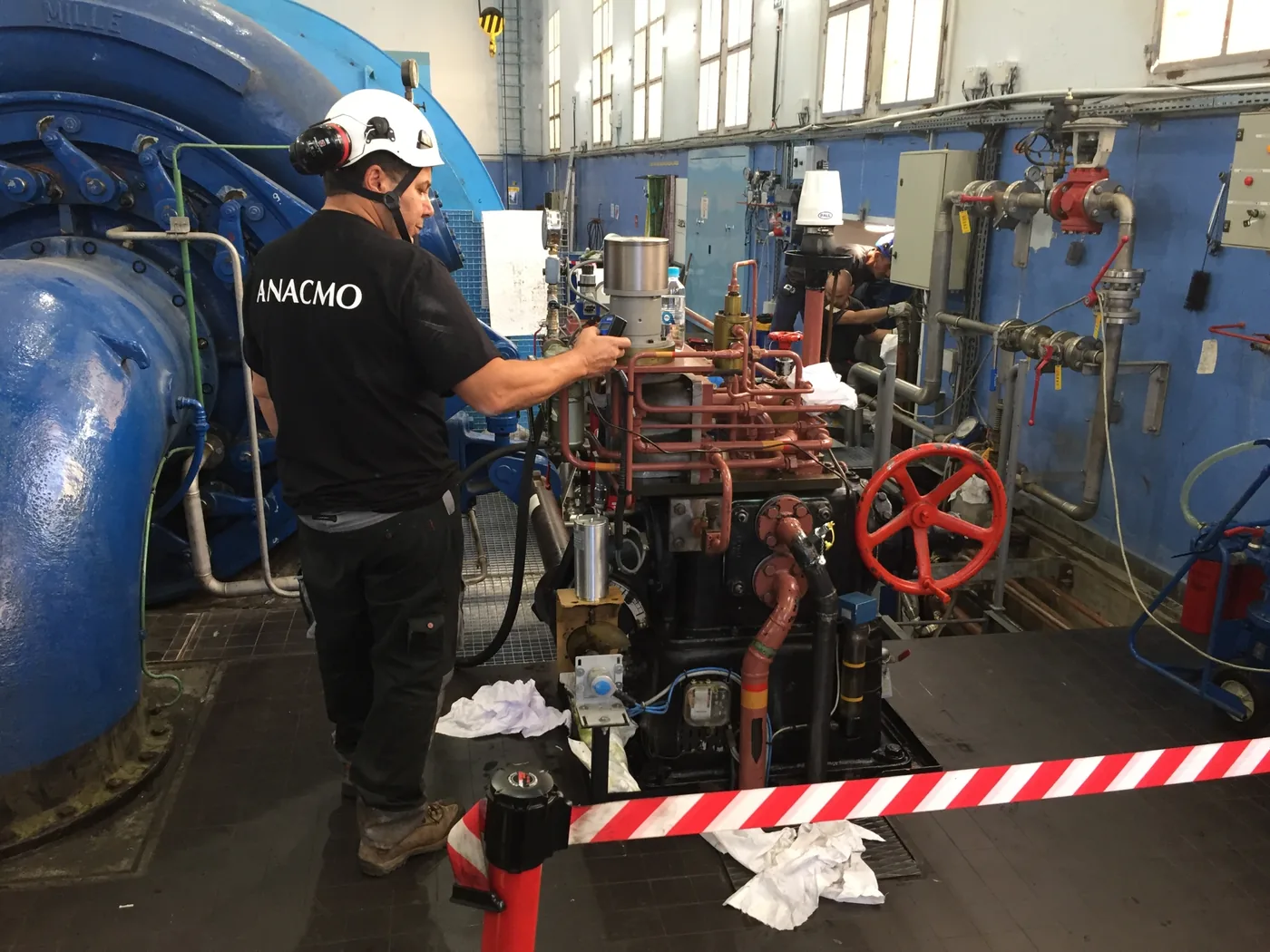Technicien ANACMO lors des essais d'une centrale hydraulique de commande de vanne de barrage