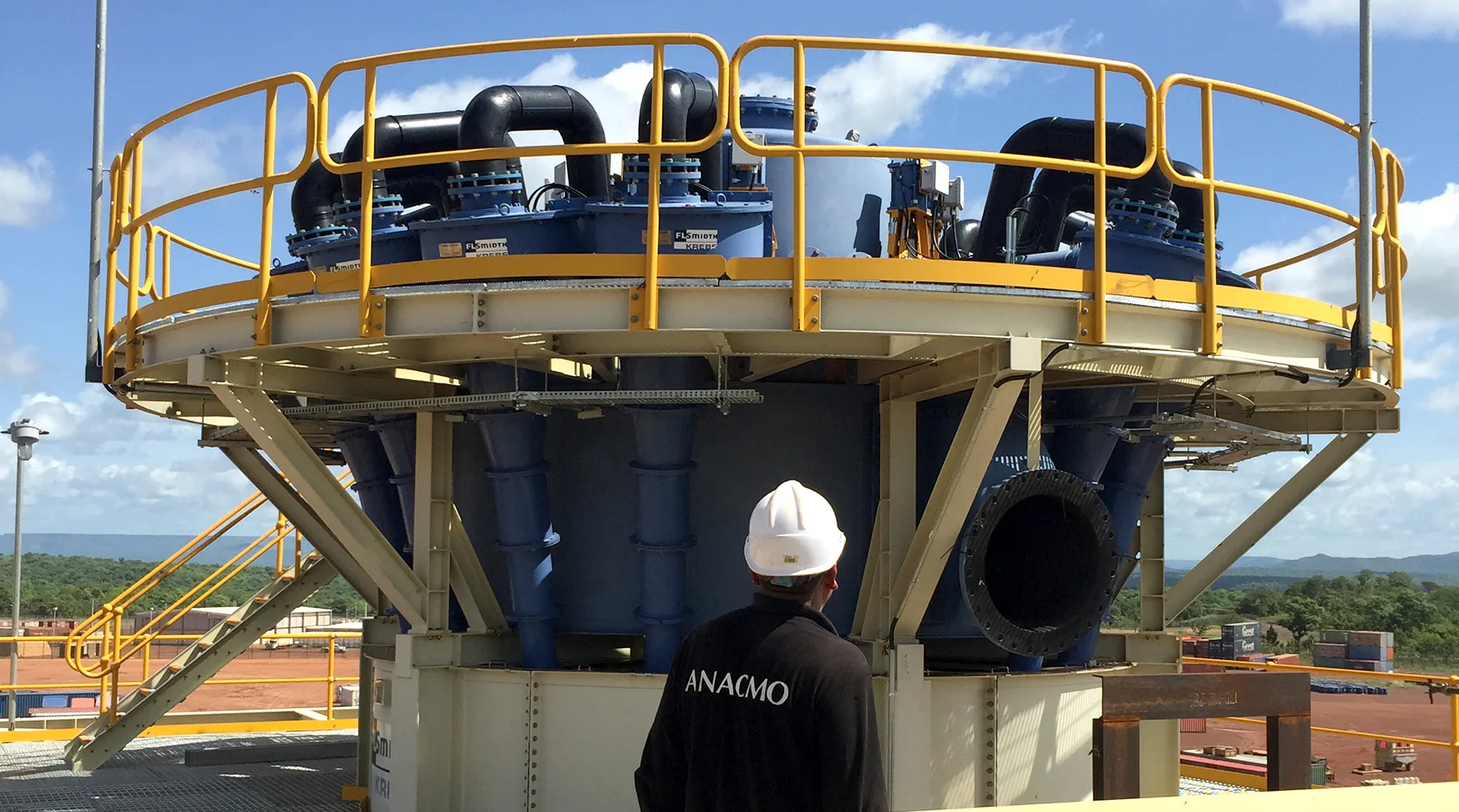 Technicien ANACMO au pied d'une batterie d'hydrocyclones sur une unité de traitement