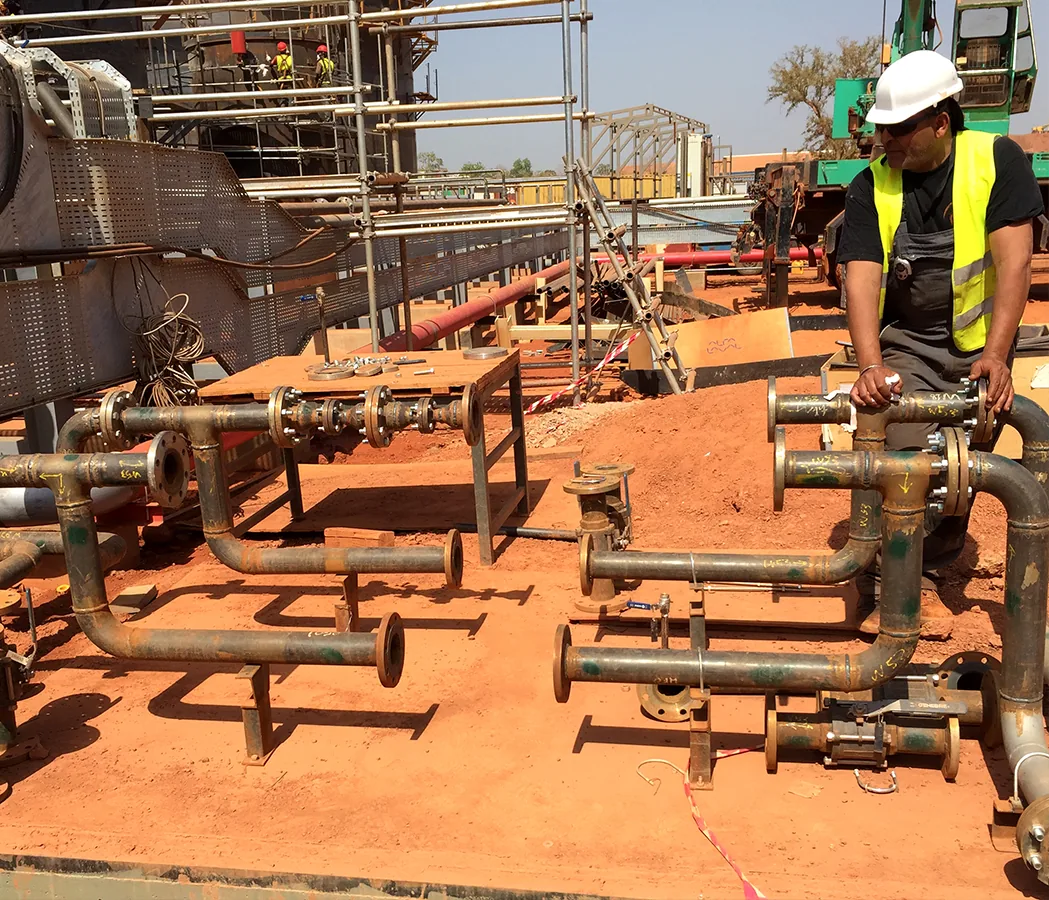 Tronçons de tuyauterie industrielle préparés au sol sur un chantier avant traitement chimique